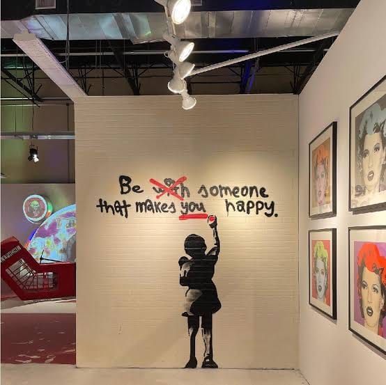 Artwork by Banksy that reads, "Be with (with is crossed out) someone that makes you (you is underlined to emphasize) happy."

Found at: https://www.facebook.com/photo/?fbid=970830994687242